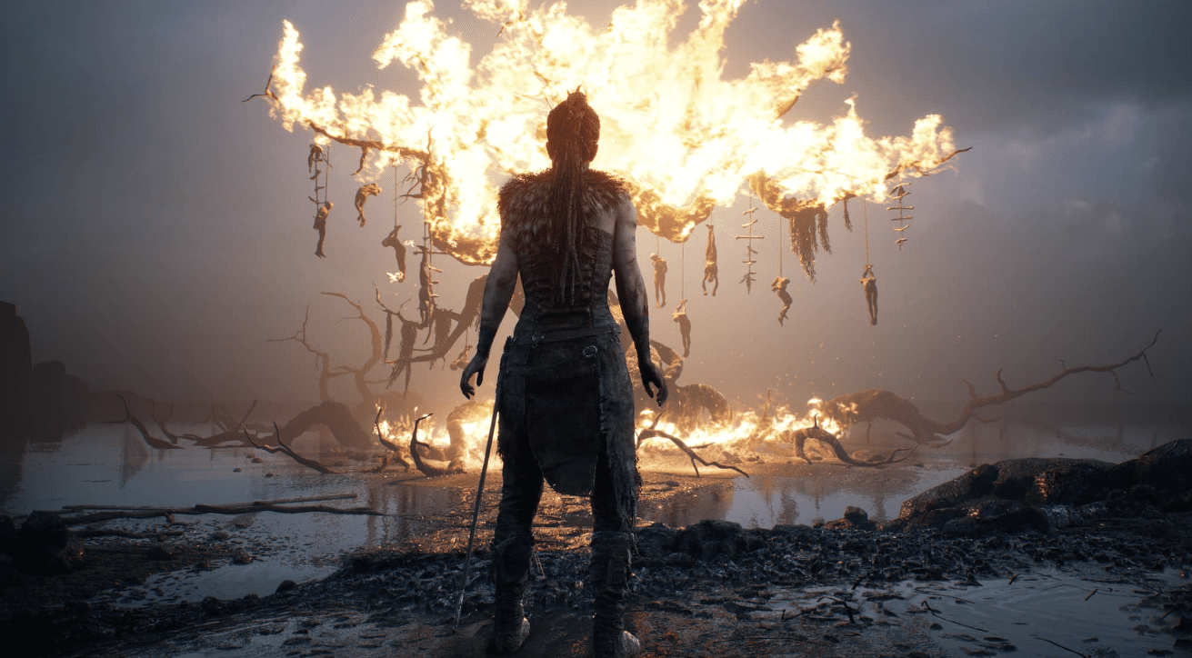 Female figure standing in front of a burning tree