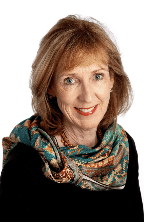 Woman in a green scarf looking at the camera smiling