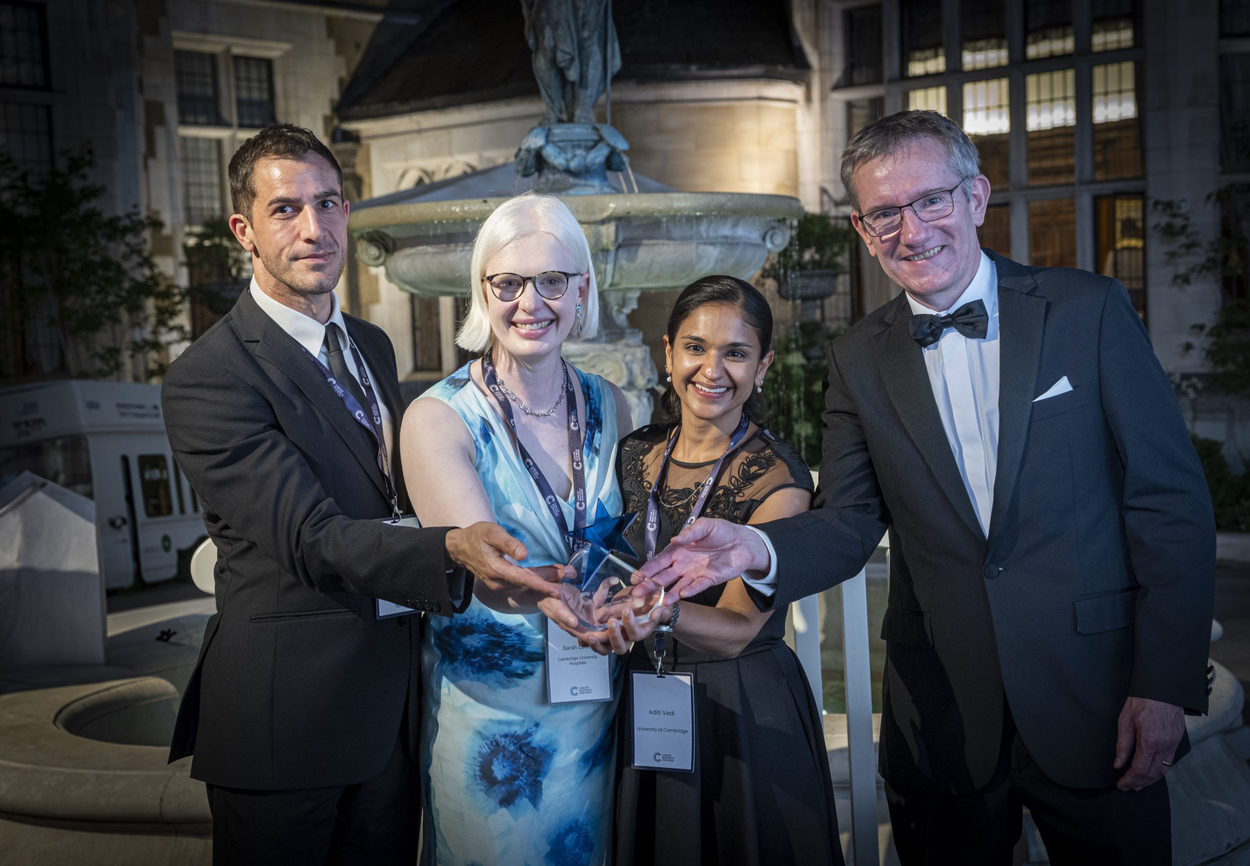 Four people smiling, looking at the camera