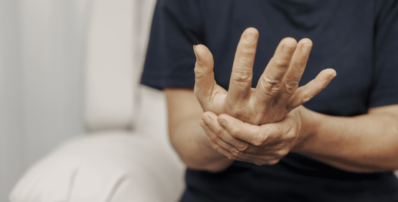 Someone clasping one hand with another hand in pain