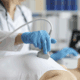 Women lying on a bed having a breast ultrasound in a hospital setting